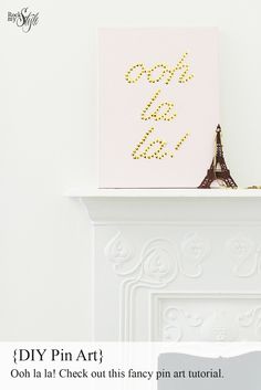 the eiffel tower has been made out of gold beads and sits on top of a fireplace mantel