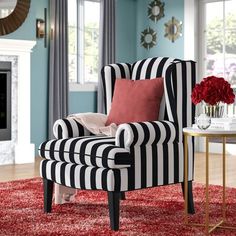 a living room with a striped chair and red rug