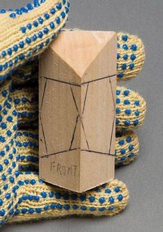 a piece of wood sitting on top of blue and yellow knitted gloves