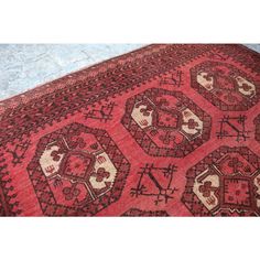 an old red rug is laying on the floor