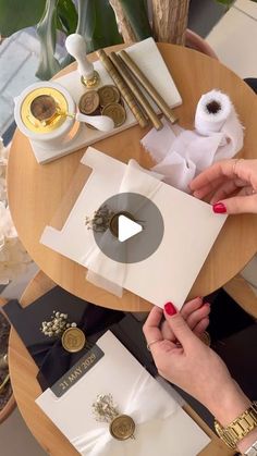 two women are making cards at a table with gold and white decorations on top of it