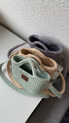 three purses sitting on top of a white table