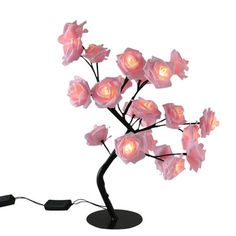 a pink flower lamp is on a black stand