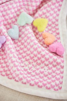 a pink and white blanket with hearts on it