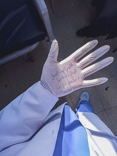 a person wearing white gloves with writing on their palm and hand in the middle of them