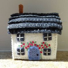 a small house made out of felt with flowers on it