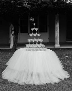 a cake that is sitting on top of a tulle skirt in front of a house