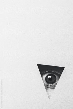 an eye peers out from behind a triangle shaped piece of paper by jodi lenski for stockstuffs