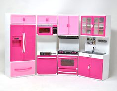 a doll house kitchen with pink and white furniture, including refrigerator, stove, oven, sink and microwave