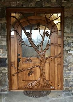 a wooden door with a tree design on the front and side glass paneled doors