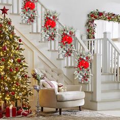 christmas decorations on the stairs next to a decorated christmas tree with red and silver poinsettis