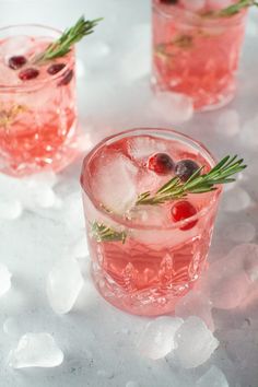 three glasses filled with ice and garnished with rosemary sprigs on top