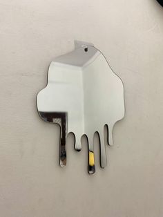 a mirror hanging on the side of a wall with paint dripping down it's sides