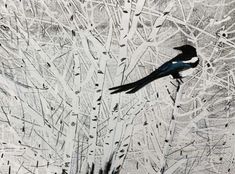 a black and white bird sitting on top of a snow covered tree branch filled with leaves