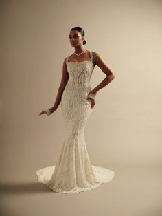 a woman in a wedding dress posing for the camera with her hands on her hips