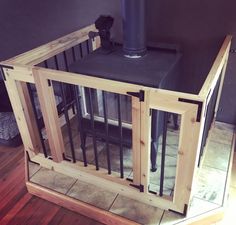 a dog kennel made out of wood and metal bars with a fireplace in the background