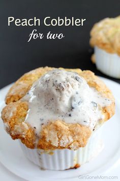 two small muffins on a white plate with icing and chocolate chip topping