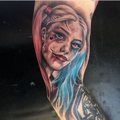 a woman's leg with a tattoo on it and an evil face in the middle