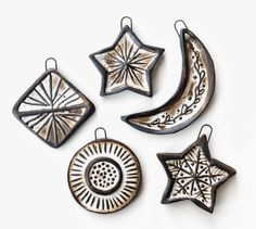 four ceramic ornaments are arranged in the shape of stars and crescents on a white background