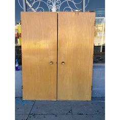 two wooden doors sitting next to each other on a sidewalk