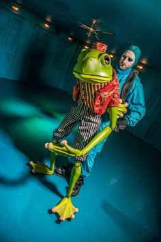 two people in costumes are holding a frog