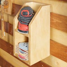 a pair of work shoes in a wooden shoe rack on the side of a wall