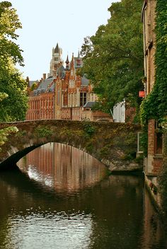 an old bridge over a river in front of a building