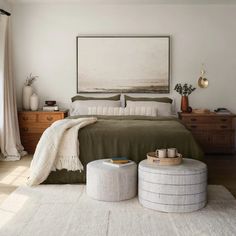 a bedroom with a large bed and two stools on the floor next to it