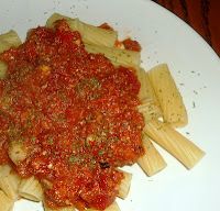 pasta with sauce and parmesan cheese on a white plate