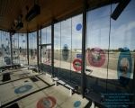 an empty bus stop with many windows and signs