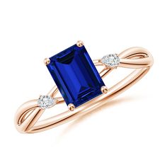 a blue sapphire and diamond ring with two diamonds on the band, set in yellow gold