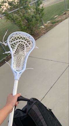 a person holding a bag with a lacrosse stick in it