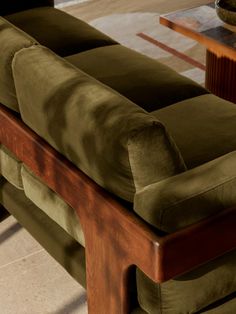 a green couch sitting on top of a wooden table