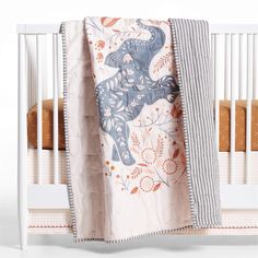 a baby crib with an elephant blanket on it