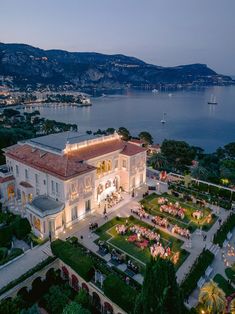 an aerial view of a mansion at night with lights on the roof and lawn area