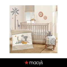 a baby crib with an elephant and giraffe bedding set on it