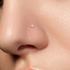 a woman's nose with a small diamond in the middle of her nose,