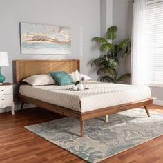 a bed sitting on top of a wooden floor next to a window