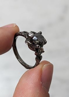 a person holding a ring in their hand with an animal on it's side