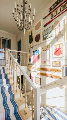 a staircase with pictures on the wall and chandelier