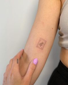 a woman's arm with a small tattoo on the left side of her arm