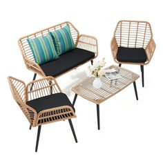 three wicker chairs and a table with pillows on it, one is black and the other is white