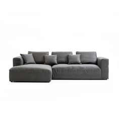 a large gray couch with pillows on it's back and side ends, in front of a white background