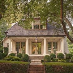 a white house surrounded by trees and bushes