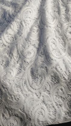 an image of white lace on a bed sheet