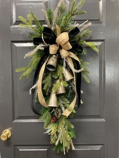 a christmas wreath with bells and evergreens hanging on a front door, decorated for the holiday season