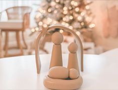 a small figurine sitting on top of a table next to a christmas tree