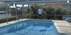 a man standing in front of a swimming pool next to a fenced in area