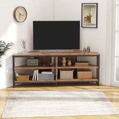 a living room with a large tv on top of a wooden entertainment center next to a potted plant