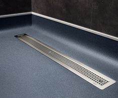 a metal grate on the ground in a bathroom